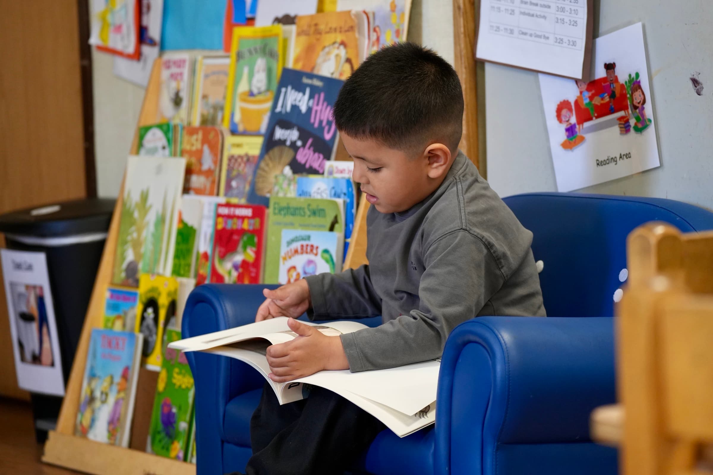 A young Bellflower Unified student reads in a classroom reading area