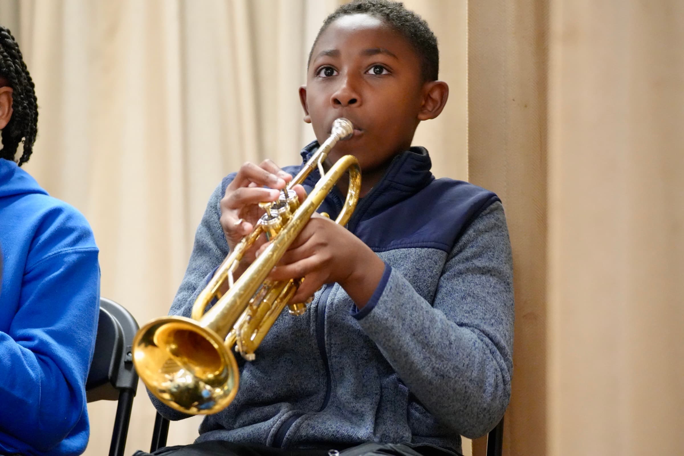 A Bellflower Unified student plays trumpet during a music class